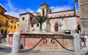 Fontana di Piazza Garibaldi di Narni, sullo sfondo la torre civica con l'orologio e l'entrata laterale della Cattedrale di San Giovenale