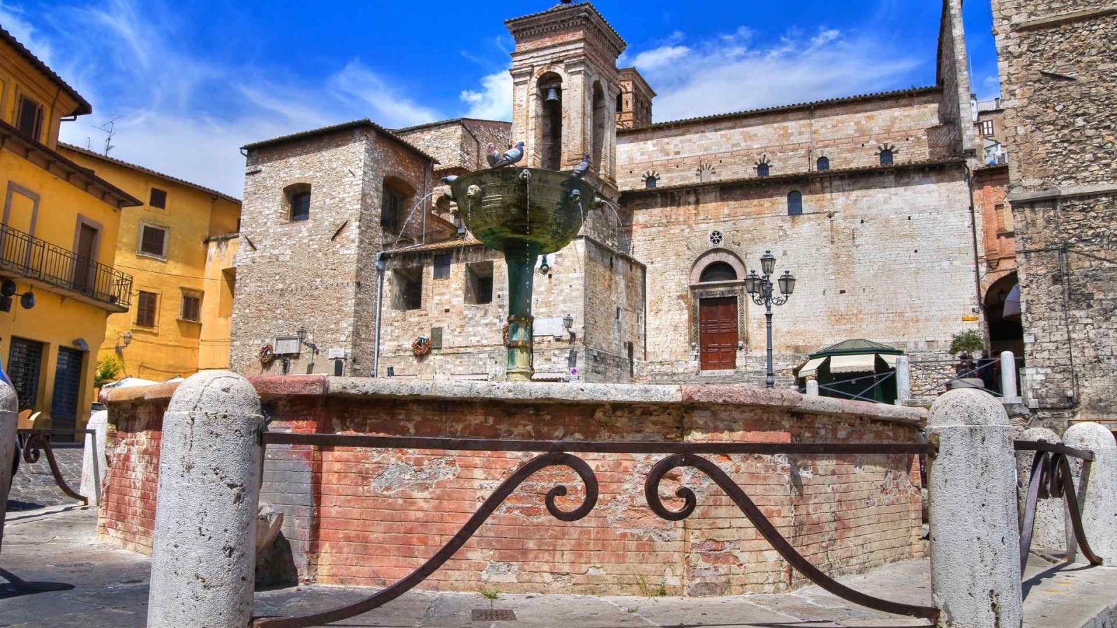 Fontana di Piazza Garibaldi di Narni, sullo sfondo la torre civica con l'orologio e l'entrata laterale della Cattedrale di San Giovenale